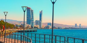 Limassol waterfront with modern buildings, Mediterranean Sea view, and a wooden pier in Cyprus